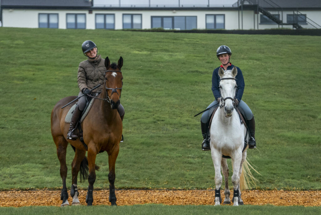 Two horses exercising on the gallops beside the Cortium clubhouse at a private Surrey equestrian estate near London